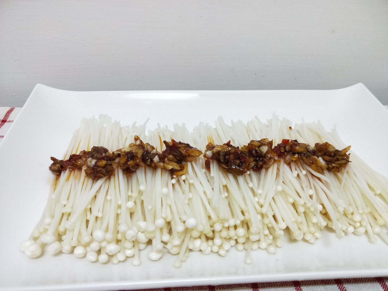 將「蒜蓉醬」均勻地淋到金針菇上。
