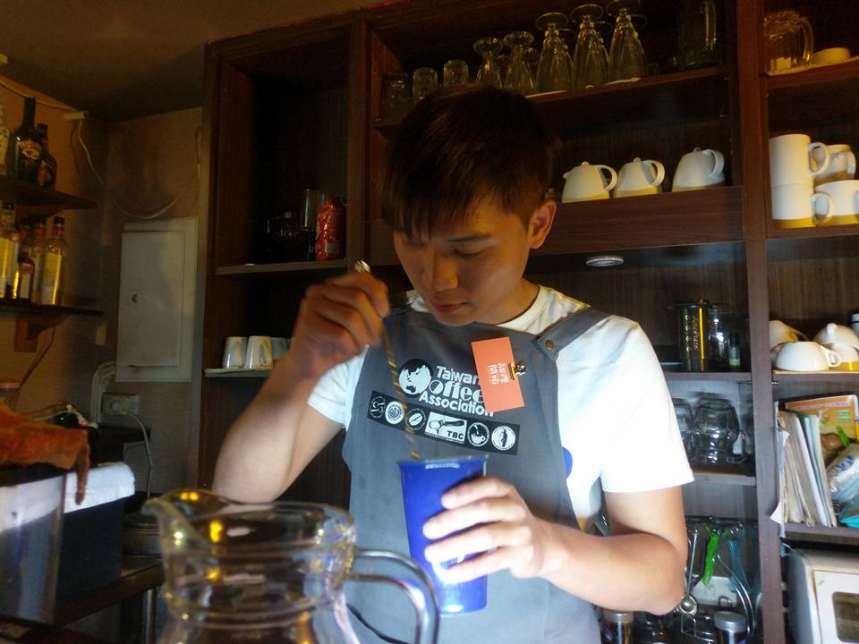 博任站在店裡的吧台專注地製作飲品，咖啡是他最大的興趣