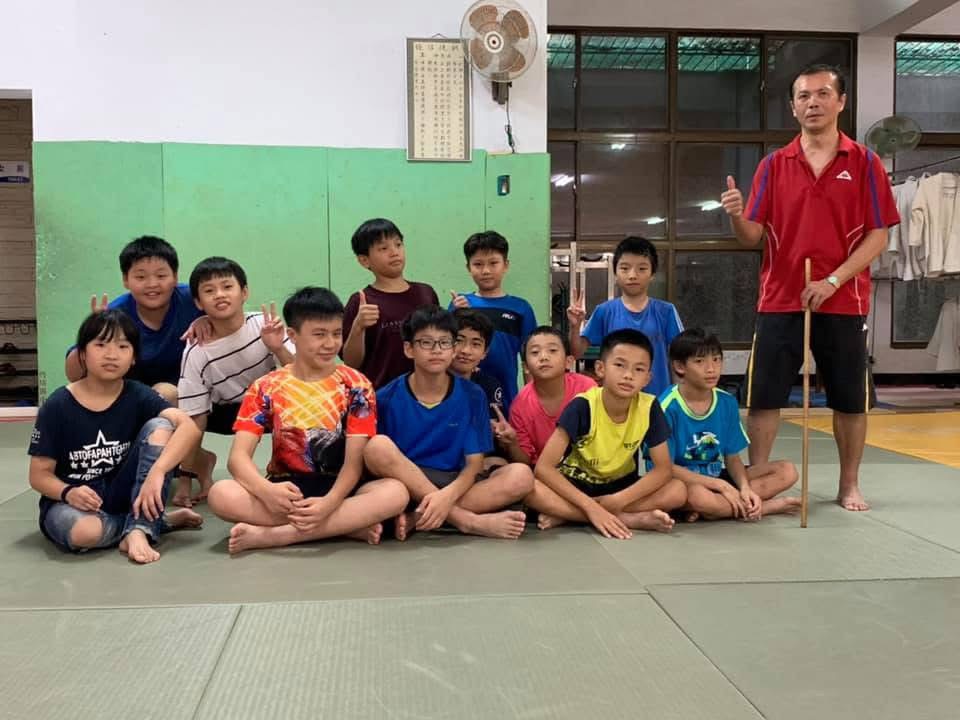 李青政自18歲起擔任台中內埔國小柔道、角力隊教練。他帶著學生到各地縣市比賽，學生也成為他的眼睛，同時培養學生能設身處地的協助他人，此照片為校外比賽時，李青政教練集合學生所拍攝。